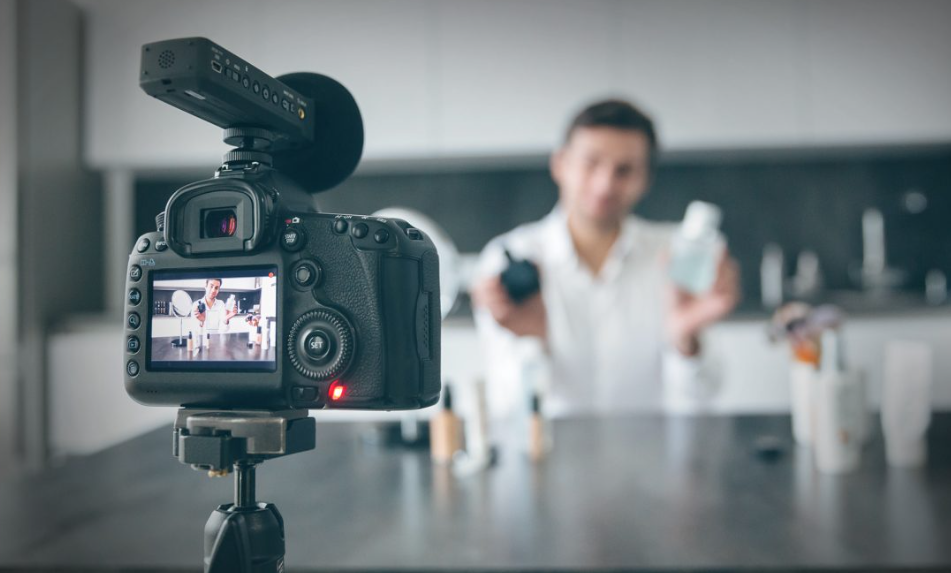 Camera recording a man reviewing products, showcasing affiliate marketing or UGC creator content creation opportunities.